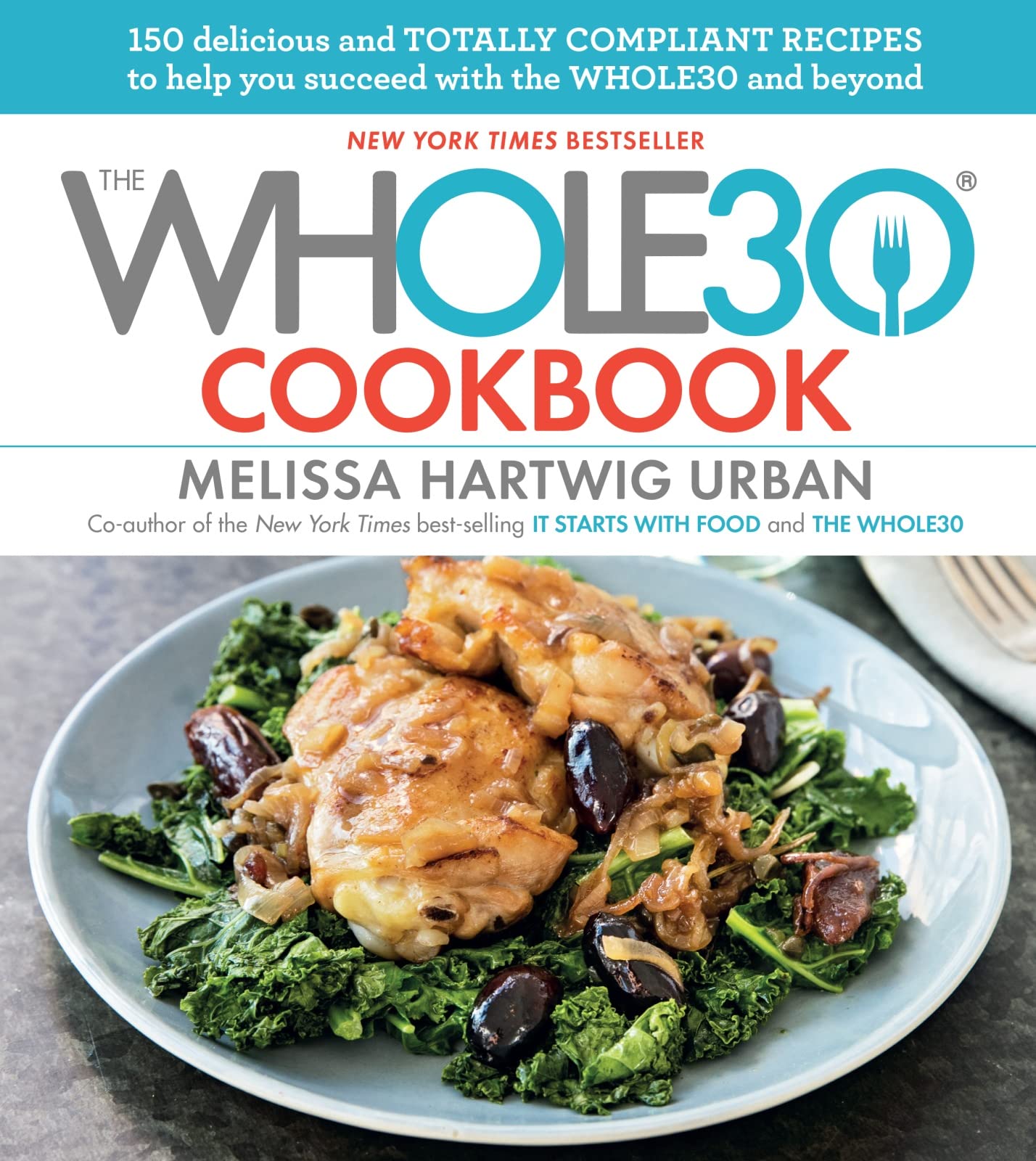 Hardback Whole30 Cookbook by Melissa Urban featuring a colorful cover and vibrant food imagery on a kitchen countertop.