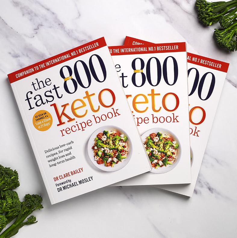 The Fast 800 Keto Recipe Book by Dr. Clare Bailey on a table, showcasing its colorful cover and paperback format.