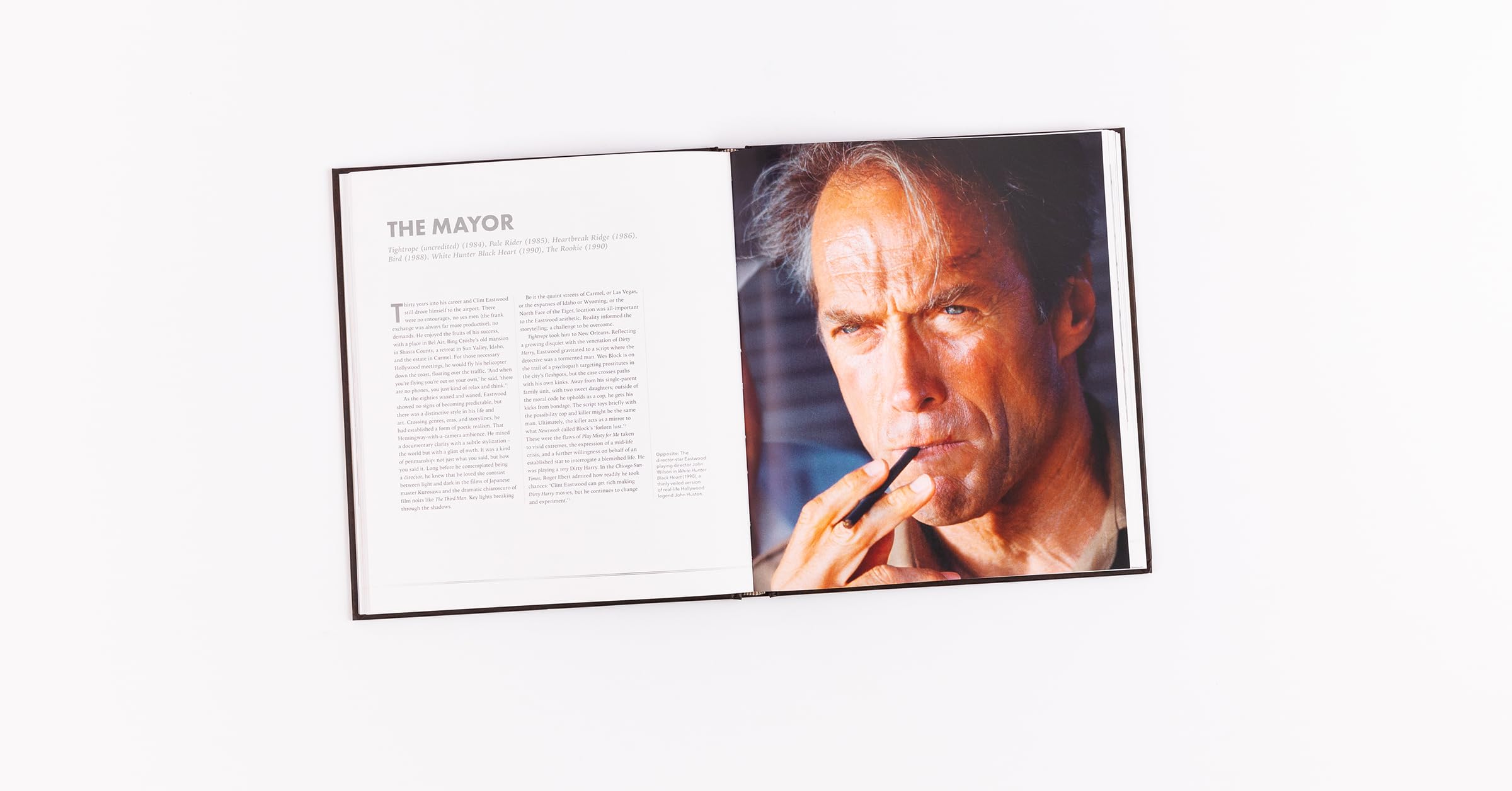 Hardback book "Clint Eastwood: Iconic Filmmaker" by Ian Nathan displayed on a wooden table with a blurred background.