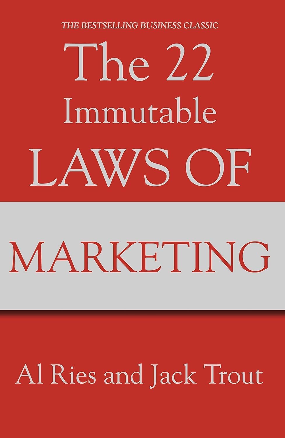 22 Immutable Laws by Al Ries, three paperback books collection set on a wooden table with a blurred background.