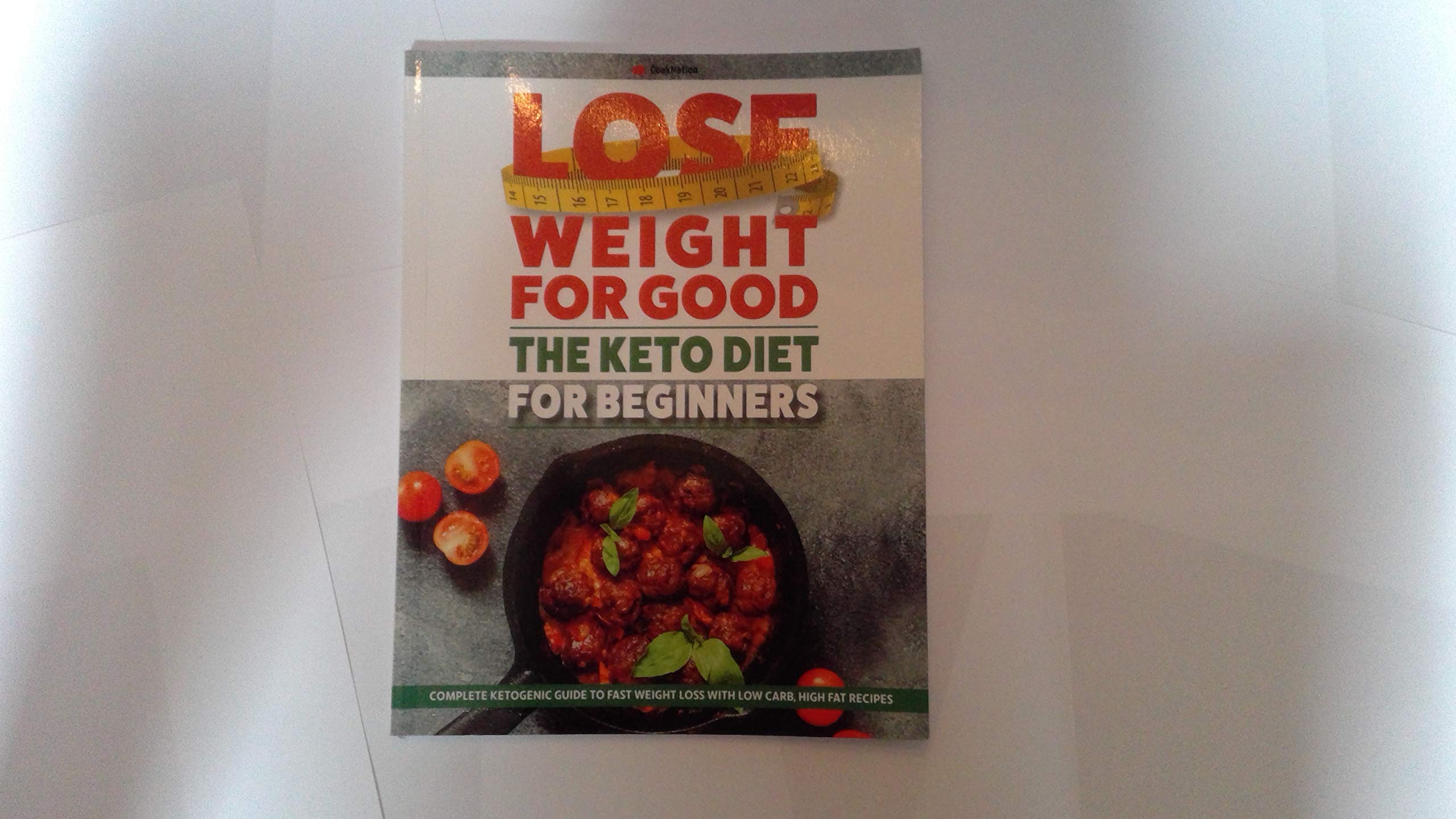 Keto Diet for Beginners paperback book by COONATION, featuring a colorful cover and informative content on weight loss.