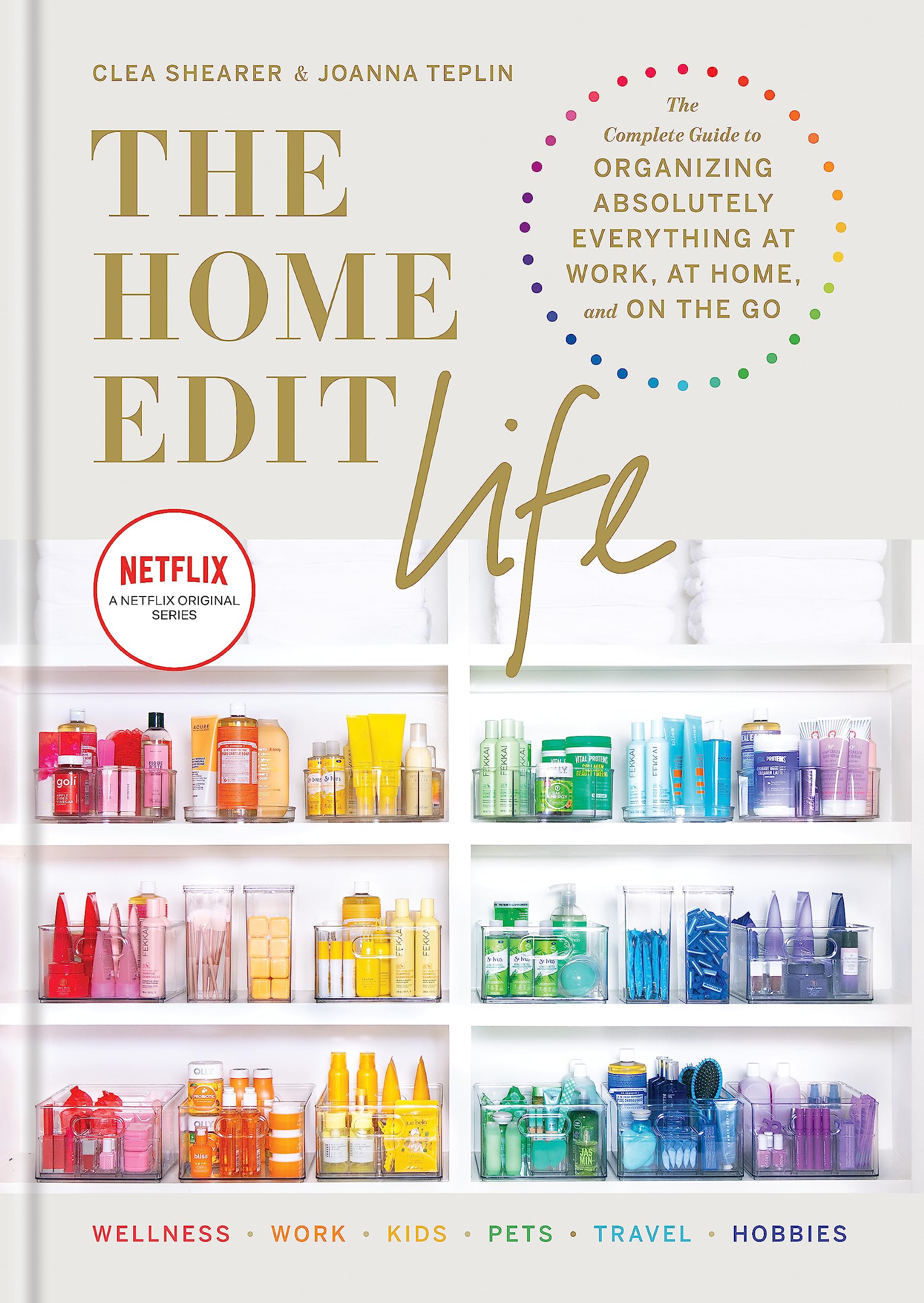 Hardback book "The Home Edit Life" by Clea Shearer and Joanna Teplin on a wooden surface with a cozy background.