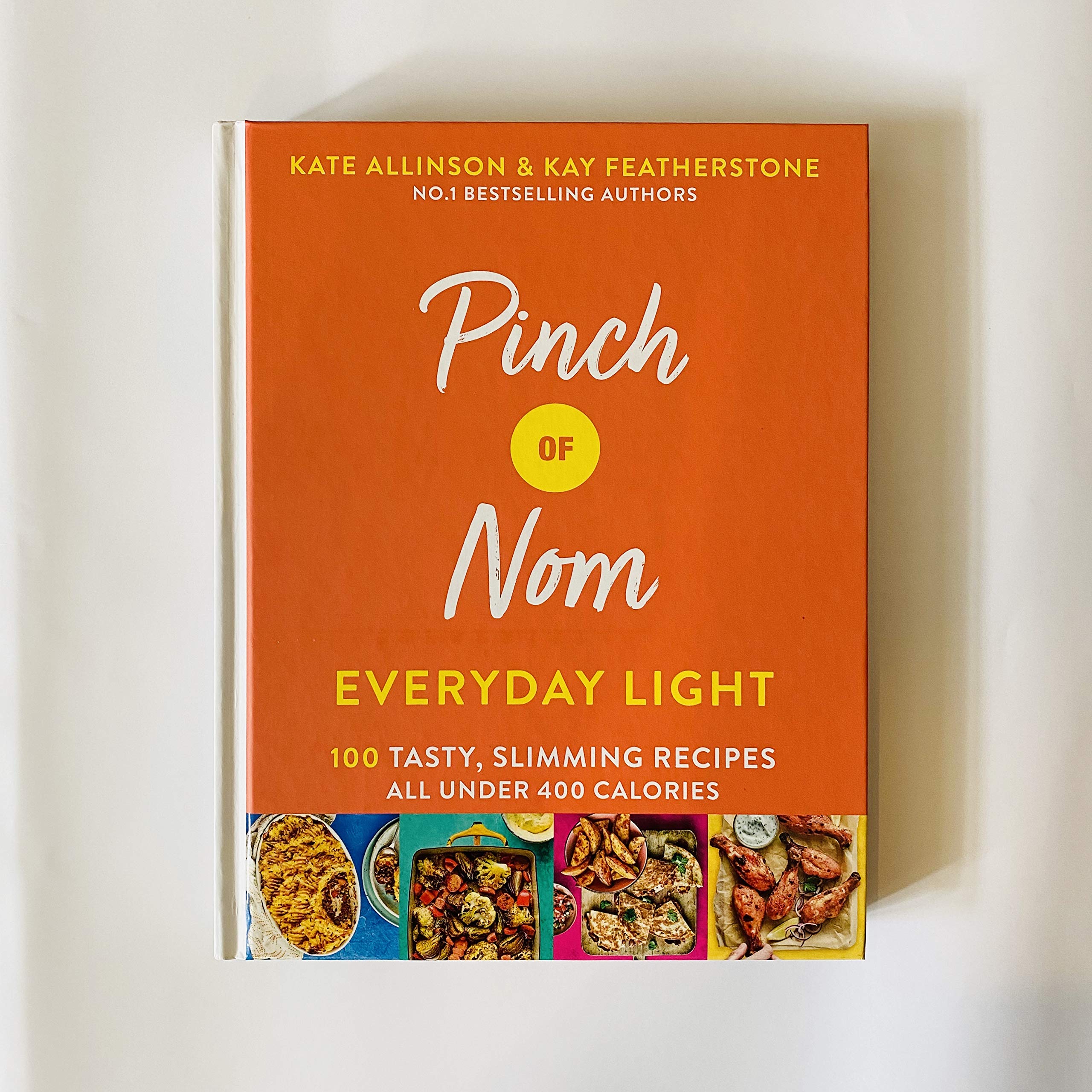 Hardback edition of "Pinch Of Nom Everyday Light" by Kay Allinson & Kate Allinson, featuring a vibrant cover design.