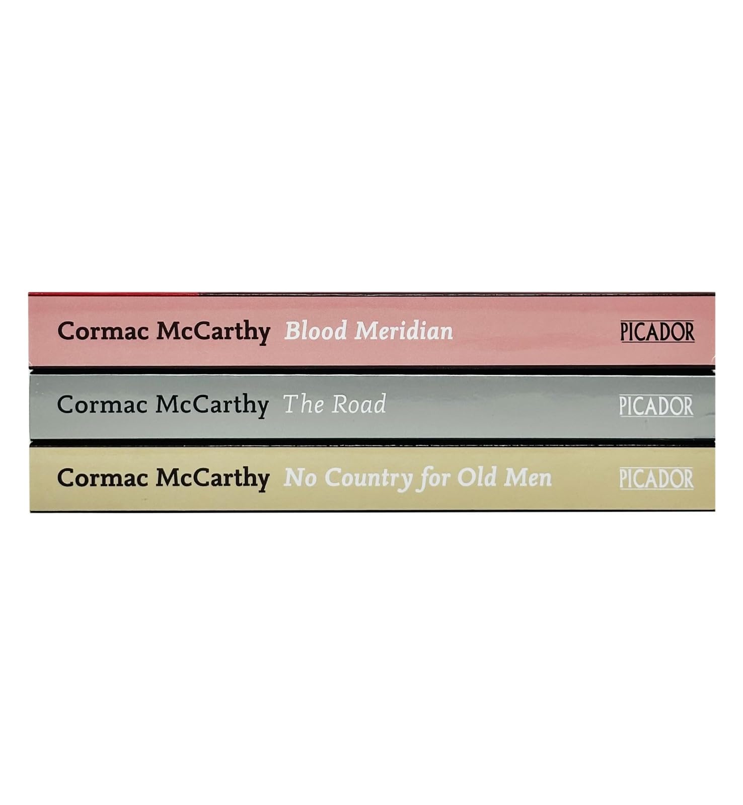 Side view of the Cormac McCarthy paperback book spines showing The Road, Blood Meridian, and No Country for Old Men titles.