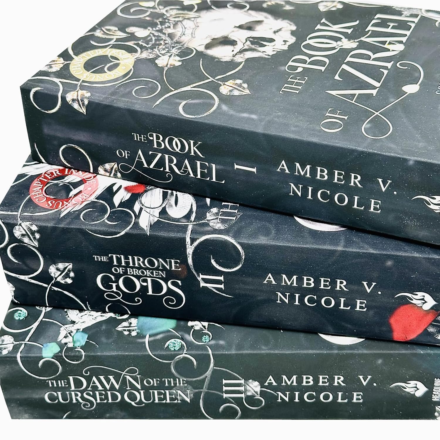 Angled close-up of the Gods & Monsters paperback collection set by Amber V. Nicole, highlighting cover art details and book edges.