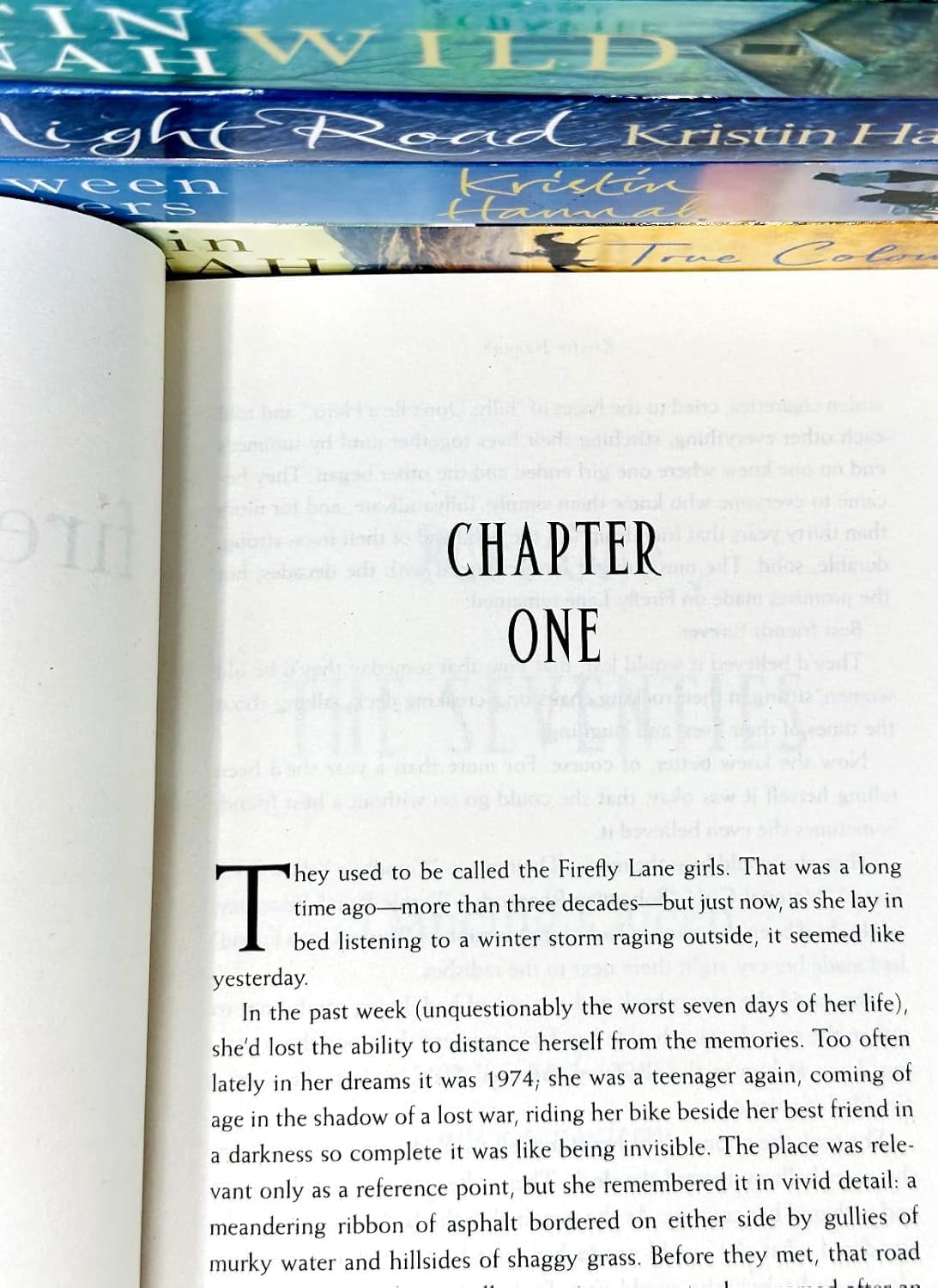 Six Kristin Hannah paperback books neatly stacked together showing the spines and titles in the collection