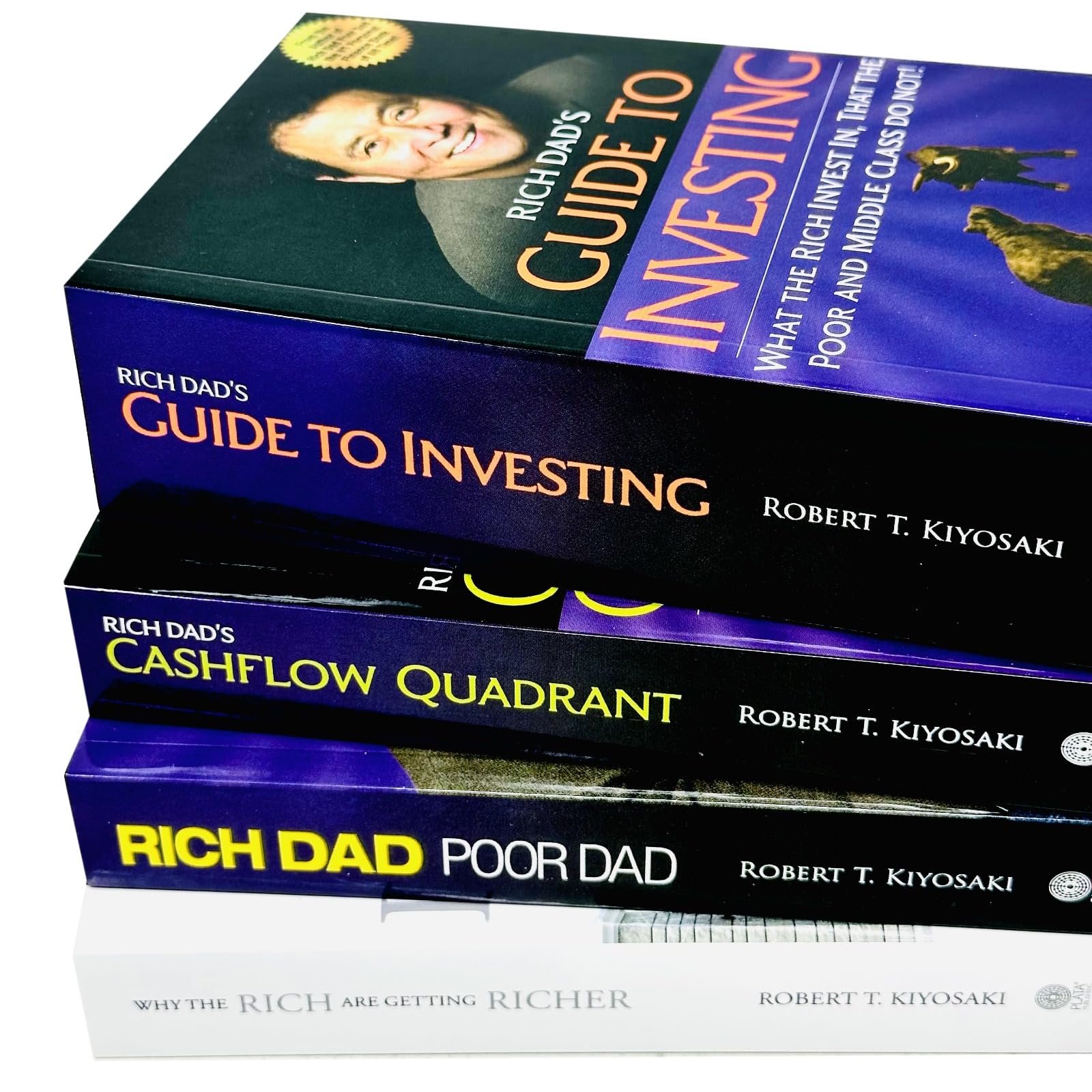 Angled view of the Rich Dad Series paperback set highlighting the Guide to Investing and Why the Rich Are Getting Richer covers.