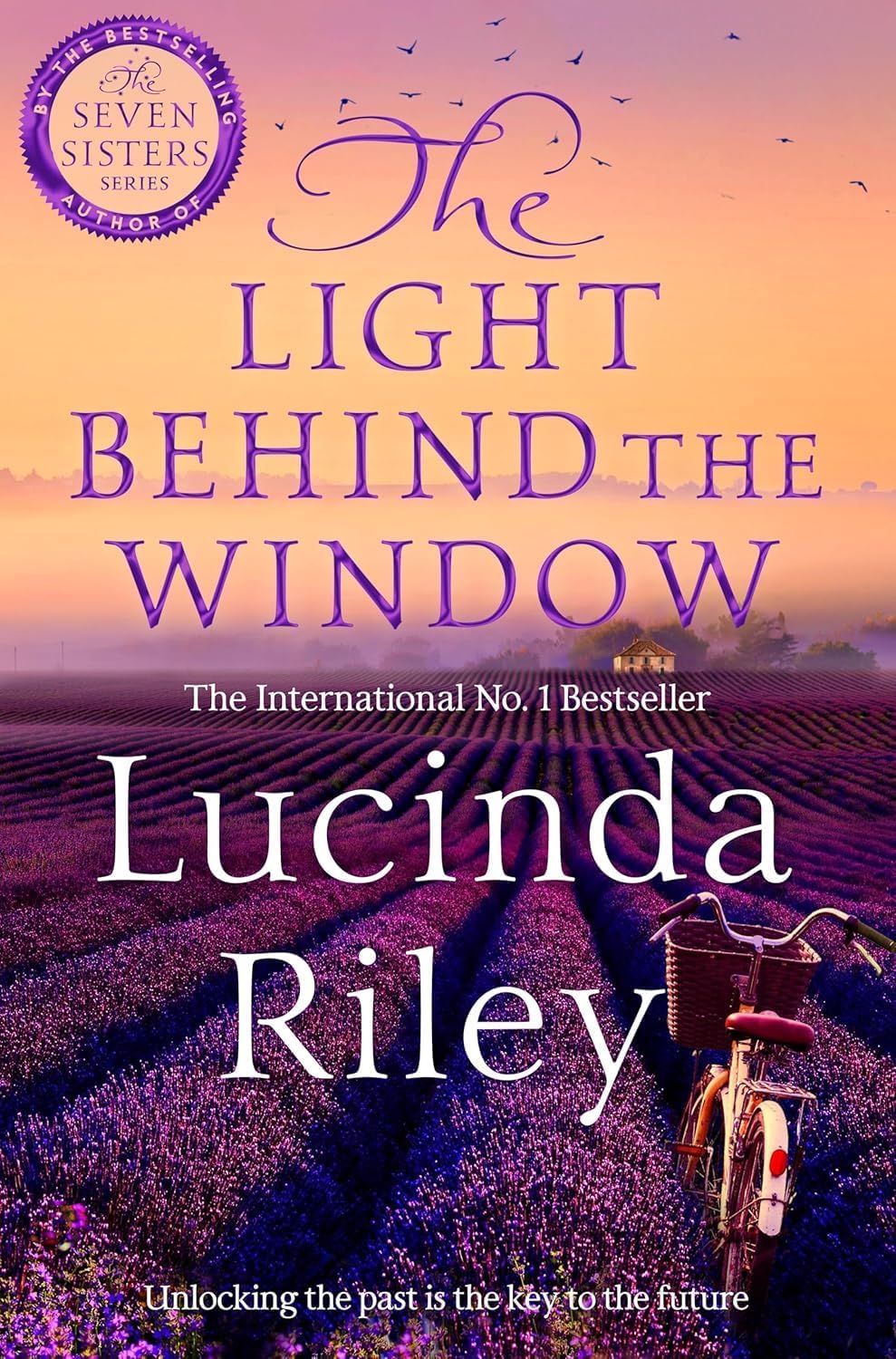Close-up front cover of The Light Behind The Window by Lucinda Riley paperback historical fiction novel