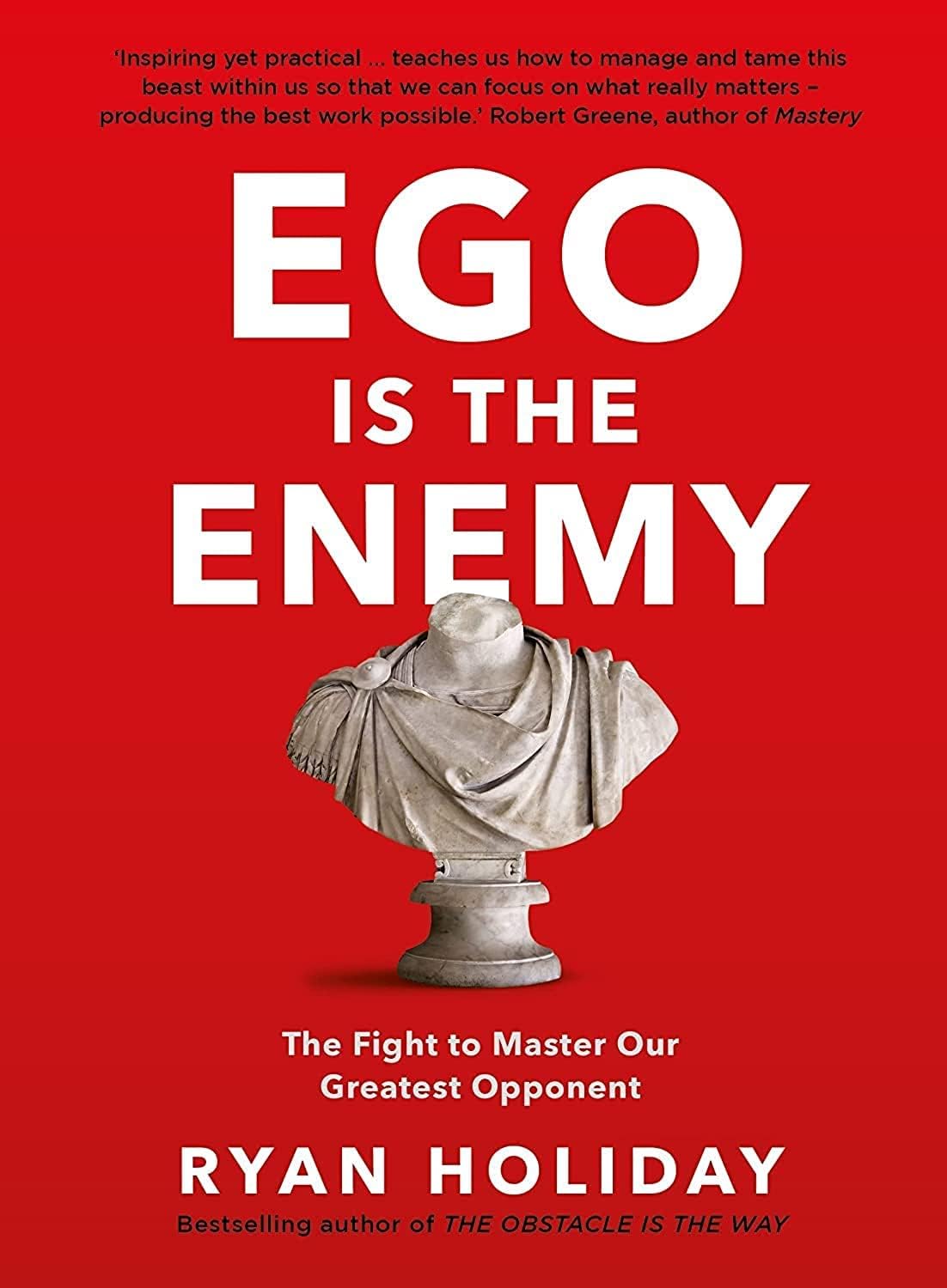 Ryan Holiday paperback book set stacked on a wooden surface showing spines of Ego Is the Enemy, The Obstacle Is the Way, and The Daily Stoic