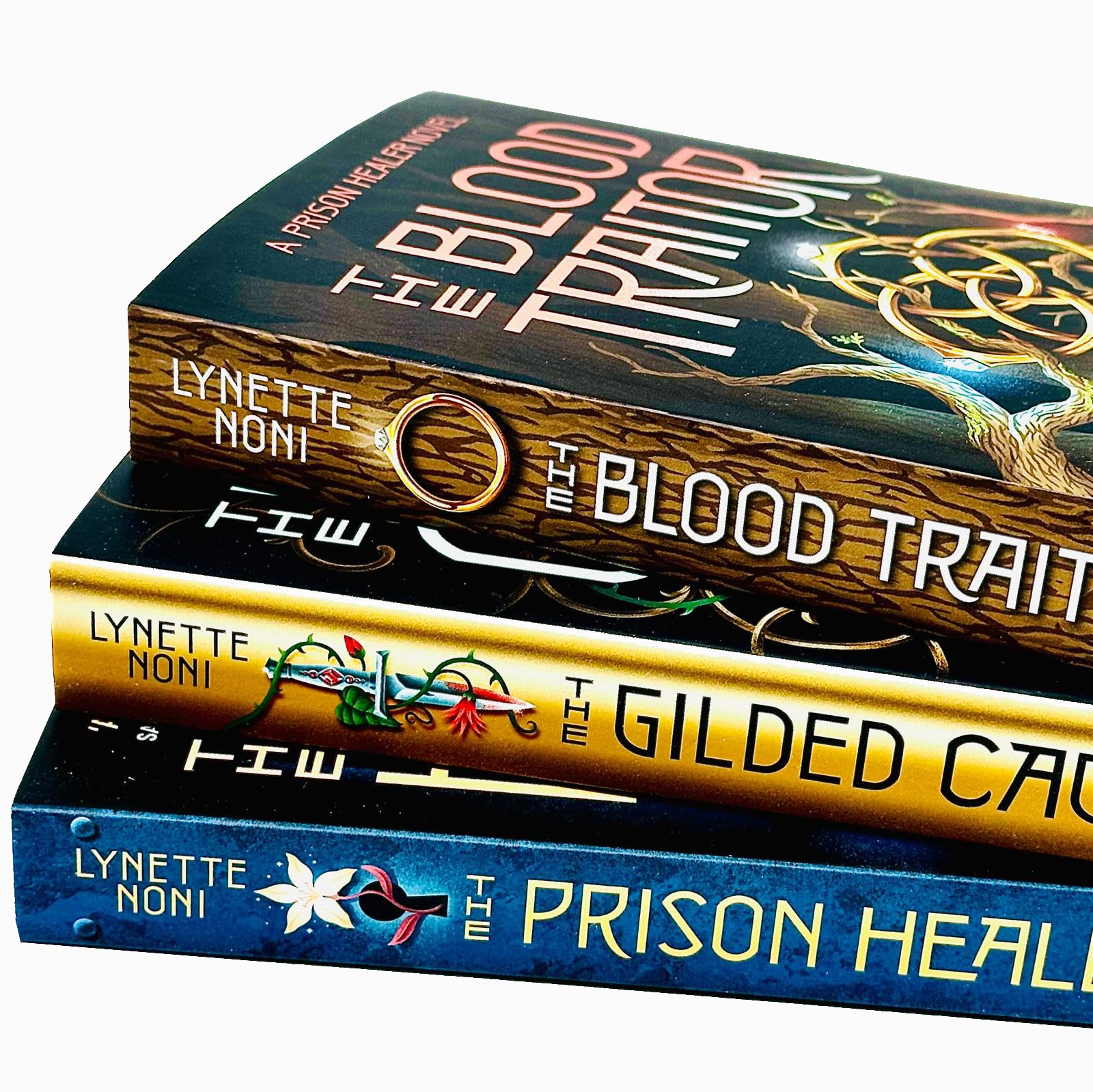 Stacked paperback copies of The Prison Healer, The Gilded Cage, and The Blood Traitor by Lynette Noni, highlighting the vibrant YA fantasy cover artwork.