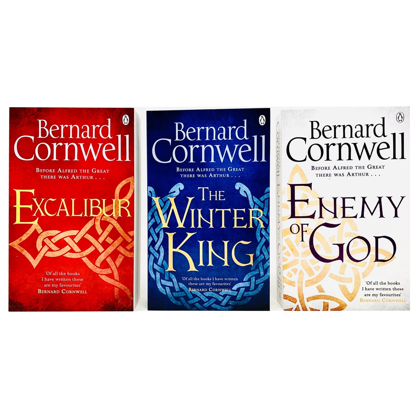 All three Warlord Chronicles paperback books by Bernard Cornwell displayed together on a wooden surface, showing spines and full set.